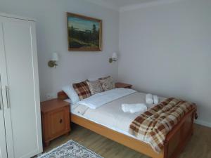 a bedroom with a bed with a picture on the wall at Willa Jana in Nałęczów