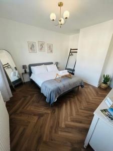 a bedroom with a bed and wooden floors and a chandelier at At Number 36 in London