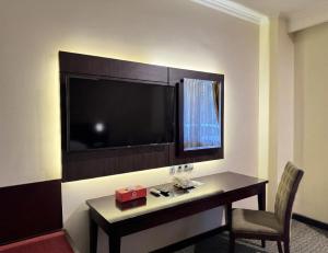 a hotel room with a desk and a large television at Citra Boutique Hotel Cikarang in Cikarang
