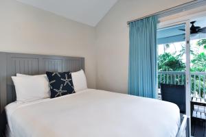 a bedroom with a bed and a large window at Crystal Waters - 2BR 2-5BA Coastal Villa in Duck Key
