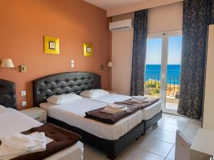 a bedroom with two beds and a view of the ocean at Plaza Hotel in Hanioti