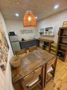 a kitchen with a wooden table in a room at forest house - Cabaña para 4 in Pichilemu +5 photos