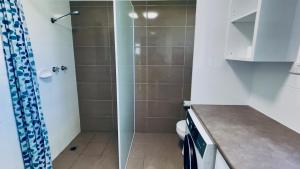 a bathroom with a shower with a toilet and a sink at Ammaboolah at Hat Head - 36 Hutcheson Street in Hat Head +33 photos