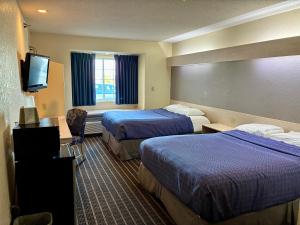 a hotel room with two beds and a flat screen tv at Chadron Inn & Suites in Chadron +9 photos
