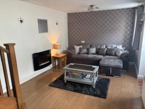 a living room with a couch and a coffee table at Tor Cefn in Kidwelly
