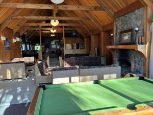 a living room with a pool table and a fireplace at Cedar Chalets and Barkers Lodge in Methven