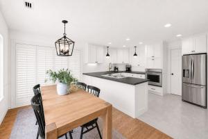 a kitchen with white cabinets and a wooden table at Vail Pines Stay in Vail