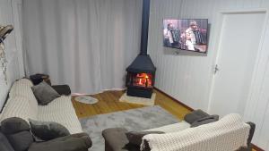 a living room with a fireplace and two couches at Casa de Campo Bella Vista in Urupema