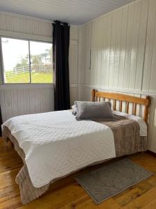 a bed in a bedroom with a window at Casa de Campo Bella Vista in Urupema