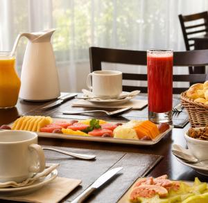 a table with a plate of food and drinks at Hotel & Residence Sol Alphaville Flat in Barueri