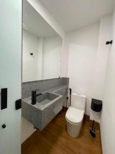 a bathroom with a sink and a toilet at Quarto Personalizado Individual aconchegante novo no coração da cidade -Ufla- restaurantes e padaria in Lavras +4 photos