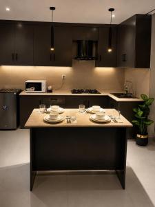 a kitchen with a table with plates and wine glasses at Lamhay Private lodges in Skardu