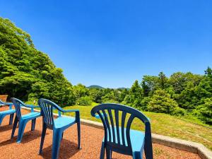 a row of blue chairs sitting on a patio at サウナパラダイス富山 in Minamiboso