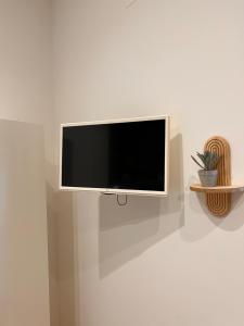 a flat screen tv hanging on a wall at Eirenè Peaceful Suites in Agrigento