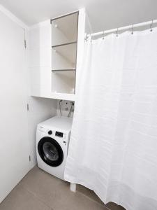 a washing machine in a bathroom with a white curtain at Extraordinario depto ejecutivo in Los Ángeles