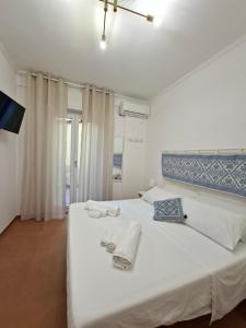 a bedroom with a white bed with towels on it at Casa del Sole Guest Rooms in Alghero