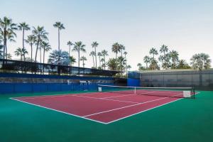 a tennis court with palm trees in the background at Naya homes: The estero beach. in Ensenada