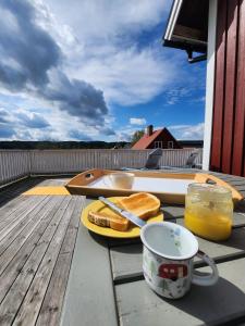 a table with a plate of sandwiches and a cup of orange juice at StayinDalsland in Dals Långed