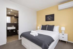 a bedroom with a large bed and a bathroom at Lakeview on Grazier in Belconnen