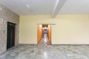 a hallway with yellow walls and a long corridor at Hotel O Maruthi in Salem