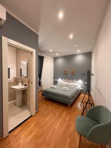 a bedroom with a bed and a bathroom with a sink at Eirenè Peaceful Suites in Agrigento