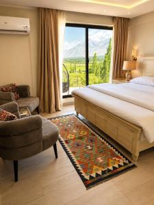 a bedroom with a bed and a couch and a window at Lamhay Private lodges in Skardu