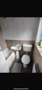a bathroom with a toilet and a sink and a tub at Central stay in Nottingham