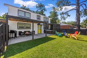 a backyard with colorful chairs and a house at The Pearl in Pensacola