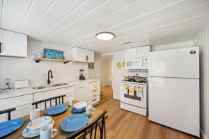 a kitchen with a table and a white refrigerator at The Pearl in Pensacola