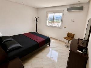 a bedroom with a black bed and a window at Tetouan house vue- chambre climatisée in Tétouan