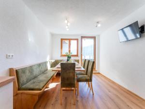 a dining room with a green couch and a table at Grünbichel Hof I in Uttendorf
