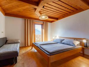 a bedroom with a bed and a large window at Grünbichel Hof I in Uttendorf