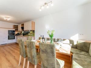 a kitchen and dining room with a wooden table and chairs at Grünbichel Hof II in Uttendorf