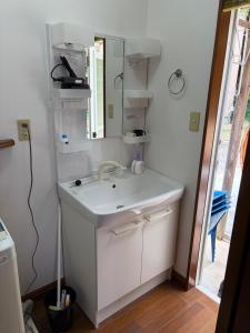 a bathroom with a white sink and a mirror at しまなみ海道-愛犬と泊まれる一棟貸し-本格バレルサウナ-ドッグラン-BBQ完備-YOSHIUMi in Imabari +30 photos
