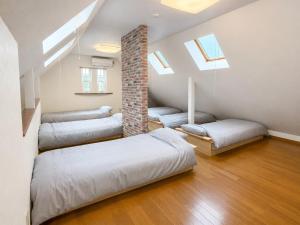 a bedroom with four beds and a couch and skylights at しまなみ海道-愛犬と泊まれる一棟貸し-本格バレルサウナ-ドッグラン-BBQ完備-YOSHIUMi in Imabari