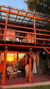 a wooden pergola with chairs and a table at Refúgio nas Nuvens Ninho das Águias in Nova Petrópolis