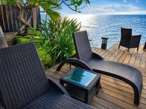 two chairs and a table on a deck with the ocean at Villa Manatini in Papeete +36 photos
