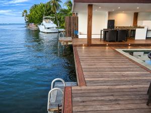 a house on the water with a dock and a boat at Villa Manatini in Papeete
