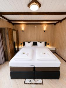 a bedroom with a large white bed in a room at Waldgasthaus & Berghotel Steinerne Renne in Wernigerode