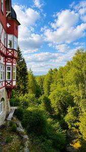 a red building in the middle of a forest at Waldgasthaus & Berghotel Steinerne Renne in Wernigerode +43 photos