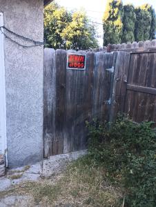 a sign on a fence with a little dog sign on it at Nice Guest House in Artesia