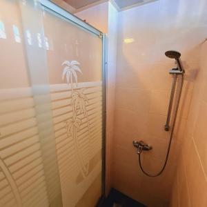 a shower with a drawing of a palm tree on the wall at Paradise Pacifica in Pacific Harbour +7 photos