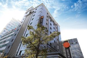a tall building with a tree in front of it at Bucheon SR Hotel in Bucheon