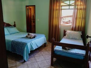 a bedroom with two beds and a cat laying on the bed at Pousada Bela Vista Santo Antônio do Manhuaçu in Caratinga +9 photos
