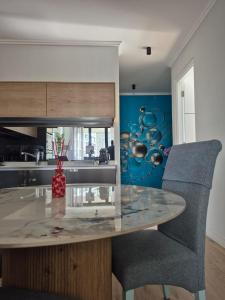 a kitchen with a glass table and a chair at Ellipse Waterfall - The Oasis Luxury Stay in Midrand