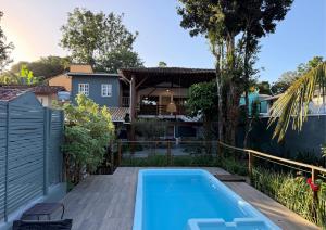 a backyard with a swimming pool and a house at Refugá in Porto Seguro