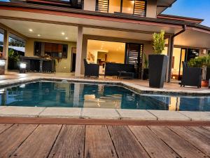 a swimming pool with chairs and a house at Villa Manatini in Papeete