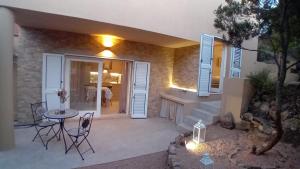 a patio with a table and chairs in front of a house at Appartamento "Hic et Nunc" in Costa Paradiso