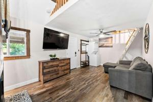 a living room with a couch and a flat screen tv at Delightful Cabin Loft Fire Pit & BBQ Julian in Julian