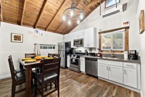 a kitchen with a table and a kitchen with white cabinets at Delightful Cabin Loft Fire Pit & BBQ Julian in Julian